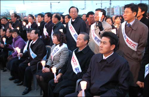 한나라당 국회의원 60여명과 김태호 도지사 등이 참석해 촛불을 들고 앉아 있다. 